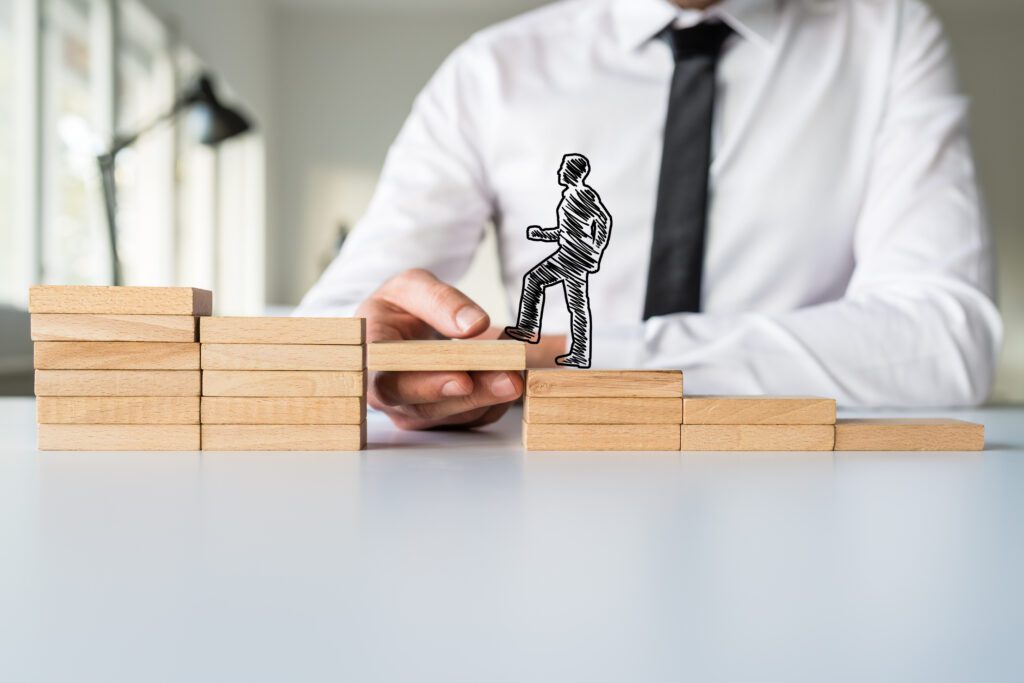 A man arranges wooden blocks along which a cartoon man is walking