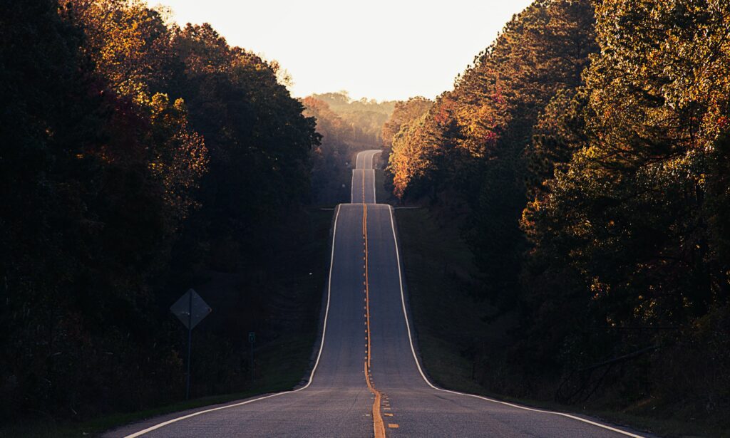 A road going between two symmetrical wooded hills